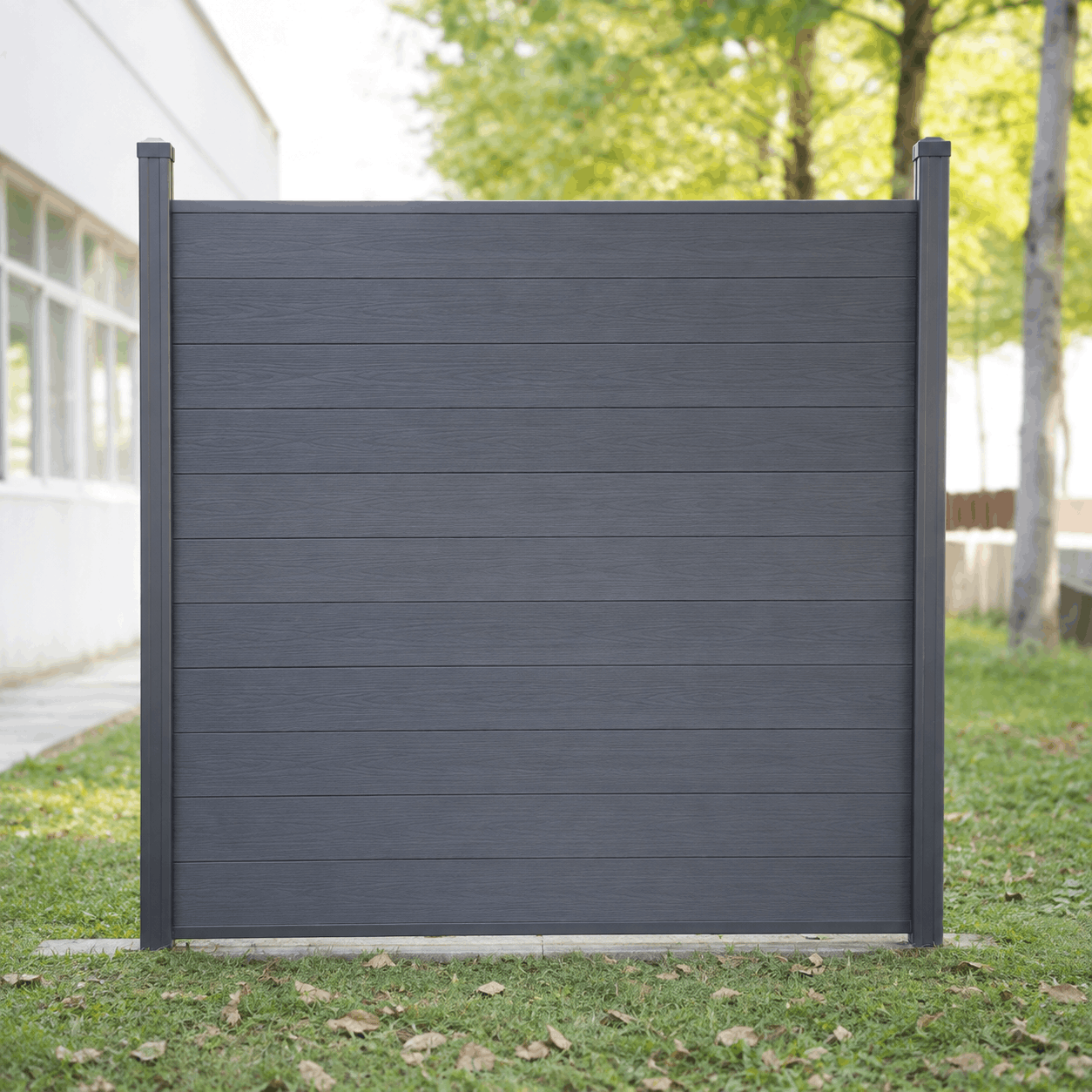 Modern dark grey horizontal slat fence panel with matching side posts, installed outdoors on a grassy area.